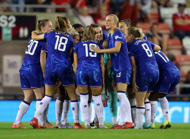 Chelsea players chat in a huddle before the second half