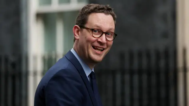 Britain's Chief Secretary to the Treasury Darren Jones walks in Downing Street in London wearing a dark blue suit, light blue shirt and matching suit