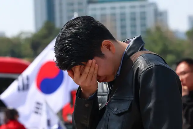 A man buries his face in his hand