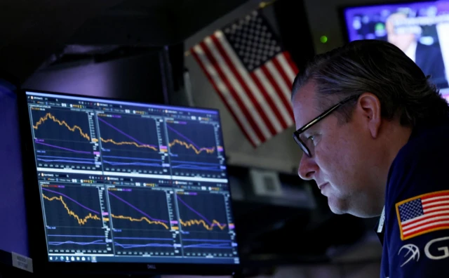 A trader works on the floor at the New York Stock Exchange in New York City