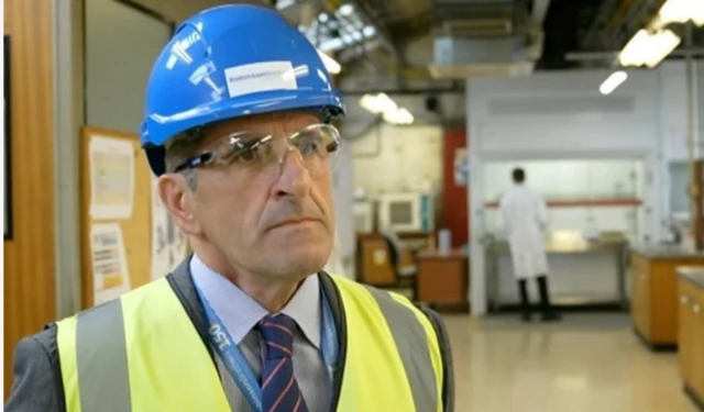 Adrian Hanrahan in a lab wearing a high vis and a helmet