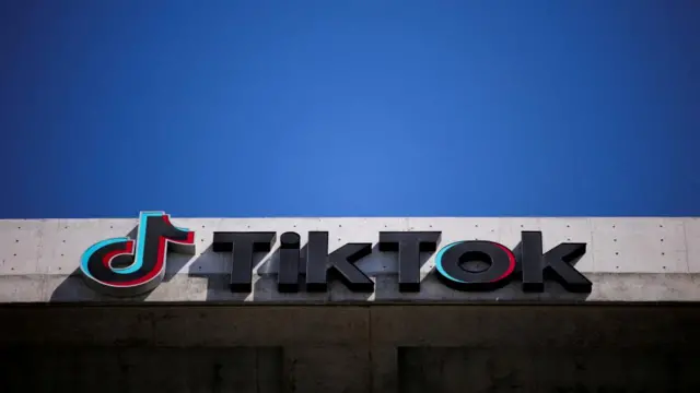 the tik tok logo is seen on the company's california office. a blue sky is seen above.