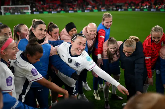 Lucy Bronze of England celebrates with teammates in a huddle