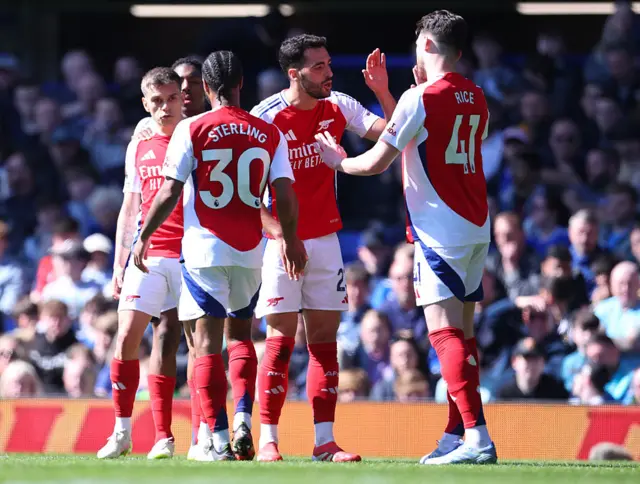 Arsenal's players celebrate scoring against Everton
