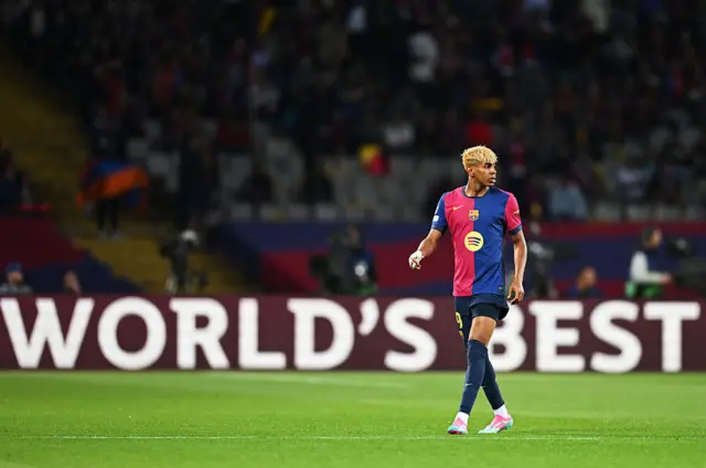 Lamine Yamal next to an advertising hoarding saying 'world's best'