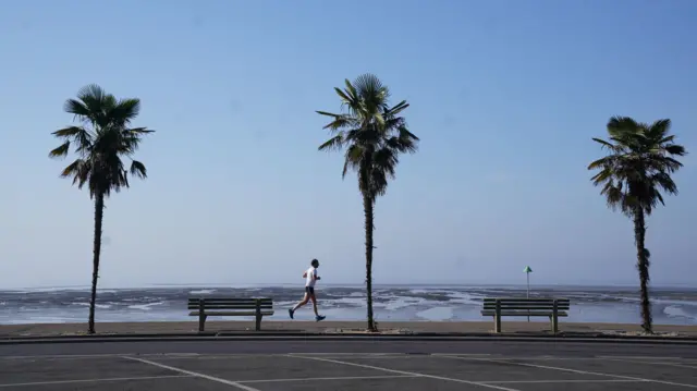A man runs along a beachfront