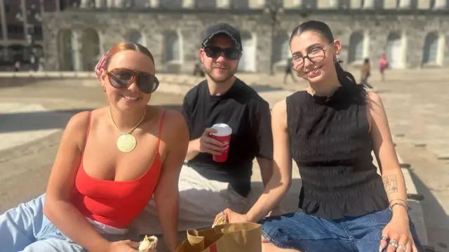 A man sits in between two women