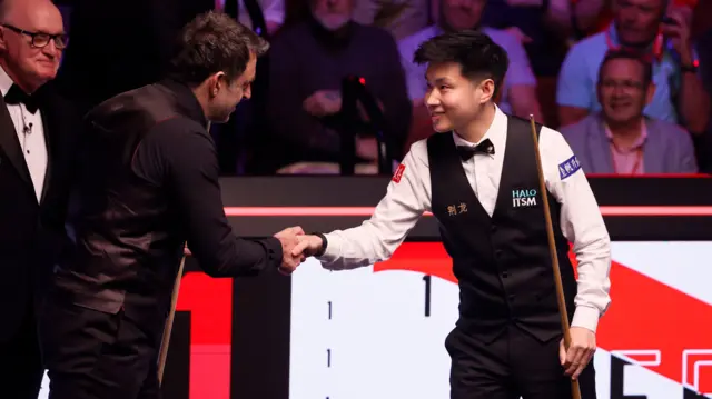 Ronnie O'Sullivan and Zhao Xintong shake hands