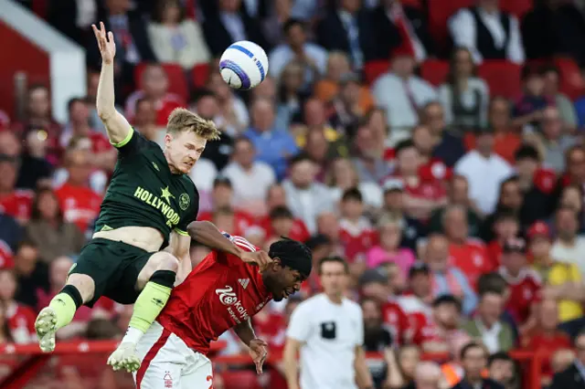 Keane Lewis-Potter (L) fights for the ball with Anthony Elanga