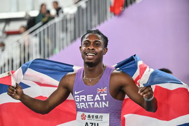 Jeremiah Azu poses for pictures with the Great Britain flag following his 60m gold medal win at the 2025 World Indoor Athletics Championships.