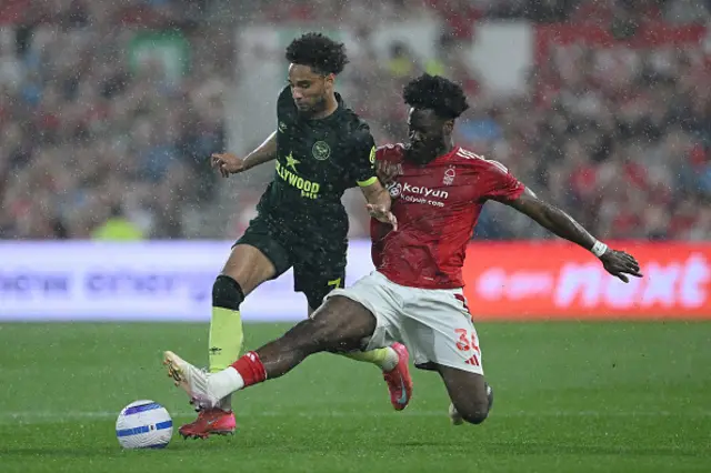 Kevin Schade of Brentford is challenged by Ola Aina