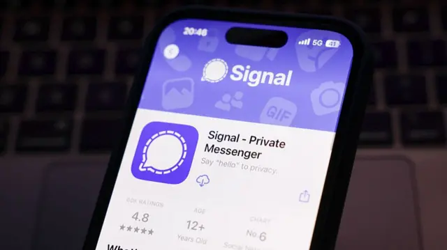A phone with the Signal app open on the app store ready to download