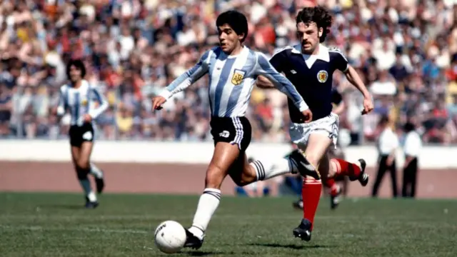 Diego Maradona runs with the ball while playing for Argentina against Scotland at Hampden Park in June 1979