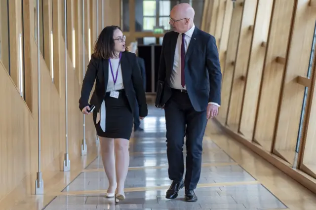 First Minister John Swinney and Deputy First Minister Kate Forbes head to the main chamber in the Scottish Parliament at Holyrood, Edinburgh.