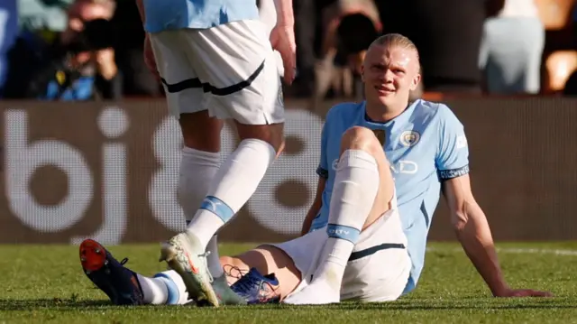 Erling Haaland sits on the field awaiting treatment during Manchester City's FA Cup quarter-final at Bournemouth