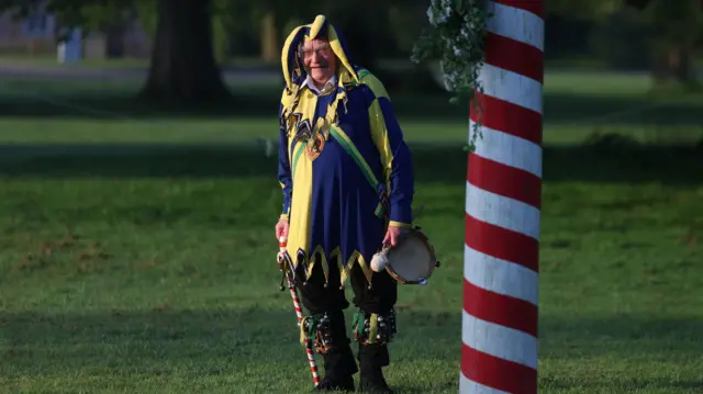 A man wears a fool's outfit