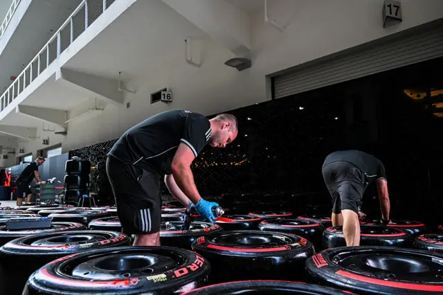 Crew members check tyres in the Miami paddock