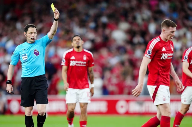 Nottingham Forest's Elliot Anderson (right) is shown a yellow card by referee Darren England