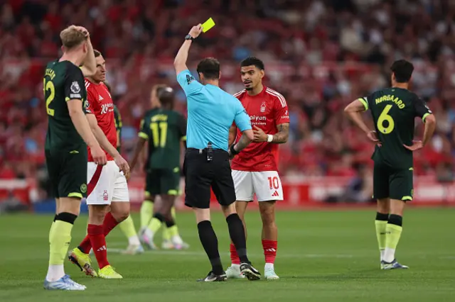 Referee Darren England shows a yellow card to Morgan Gibbs-White