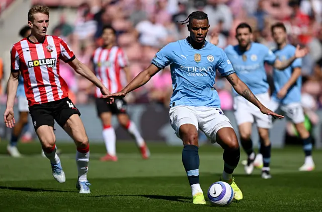 Manuel Akanji of Manchester City controls the ball under pressure from Flynn Downes