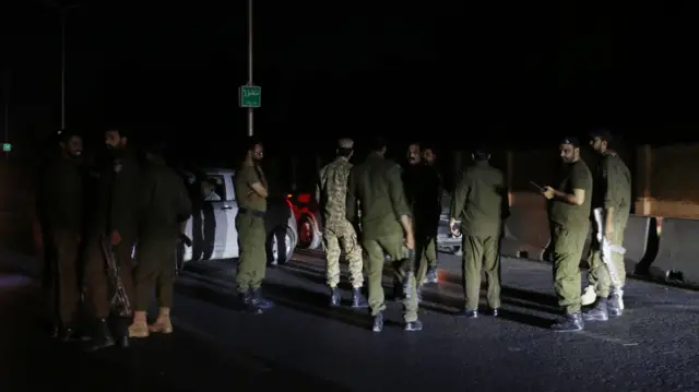Pakistani security officials, wearing combat gear, gather