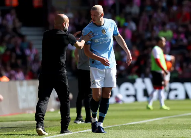 Pep Guardiola, Manager of Manchester City, gives instructions to Erling Haaland