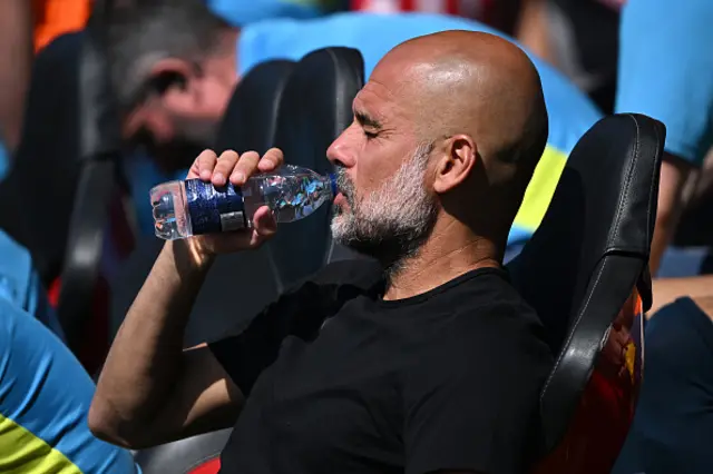 Pep Guardiola, Manager of Manchester City, drinks from a bottle of water