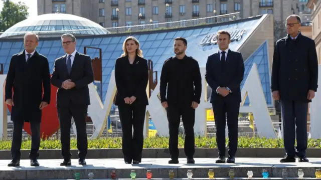 Poland's Prime Minister Donald Tusk, Ukraine's President Volodymyr Zelensky, Britain's Prime Minister Keir Starmer, France's President Emmanuel Macron, Ukraine's First Lady Olena Zelenska and Germany's Chancellor Friedrich Merz pay their respects to the victims of war at the Memorial for the Fallen at the Independence Square in Kyiv