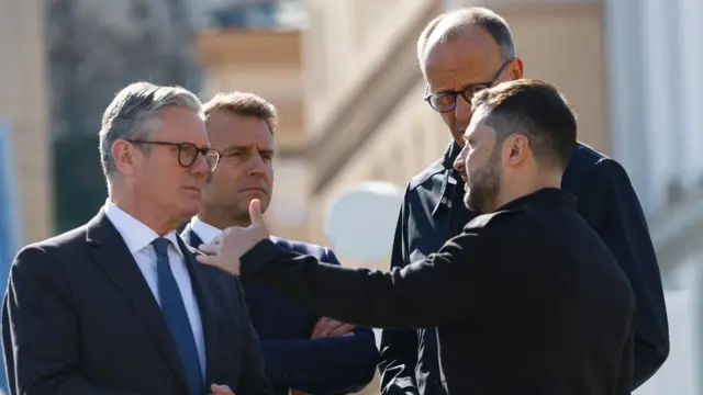 Starmer, Macron and Merz look at Zelensky as he talks in Kyiv.
