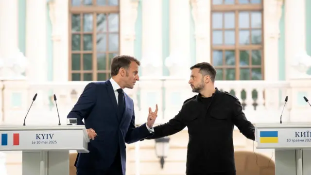 Macron speaks to Zelensky behind a podium in Kyiv.