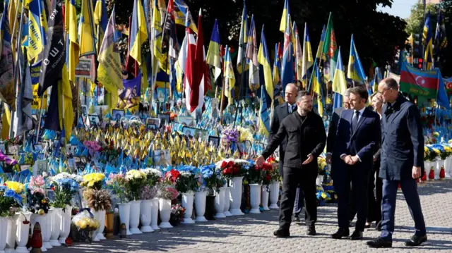 Poland's Prime Minister Donald Tusk, Ukraine's President Volodymyr Zelensky, Britain's Prime Minister Keir Starmer, France's President Emmanuel Macron, Ukraine's First Lady Olena Zelenska and Germany's Chancellor Friedrich Merz pay their respects to the victims of war at the Memorial for the Fallen at the Independence Square in Kyiv
