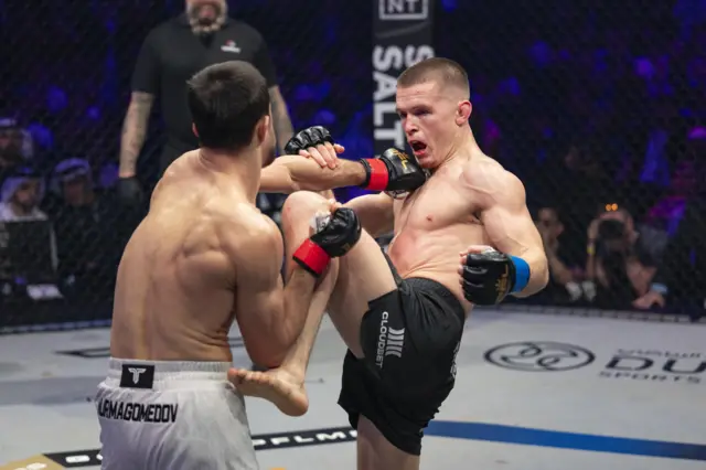 Paul Hughes sinks a knee into Usman Nurmagomedov