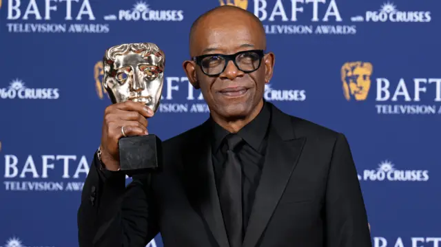 Lennie James holding up his Bafta gong