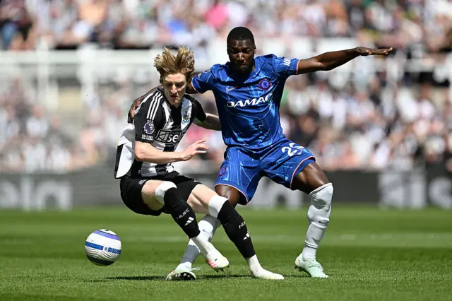 Anthony Gordon of Newcastle United is challenged by Moises Caicedo of Chelsea during the Premier League match between Newcastle United FC and Chelsea FC at St James' Park on May 11, 2025 in Newcastle upon Tyne, England.