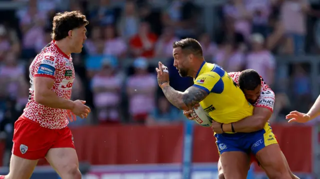 Warrington's Paul Vaughan is tackled by Leigh