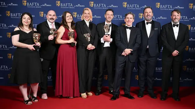 Cast of Would I Lie to You on red carpet holding BAFTA awards
