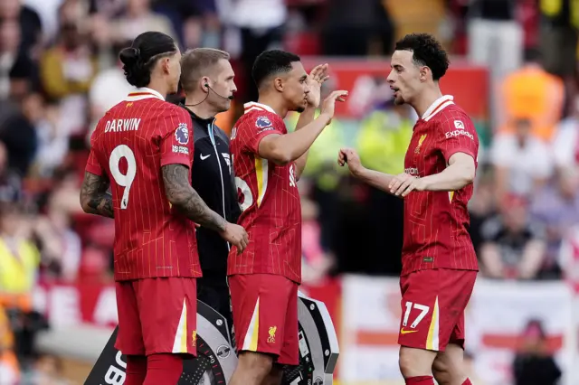 Liverpool substitute Trent Alexander-Arnold (centre) embraces Curtis Jones (right) as he replaces Conor Bradley