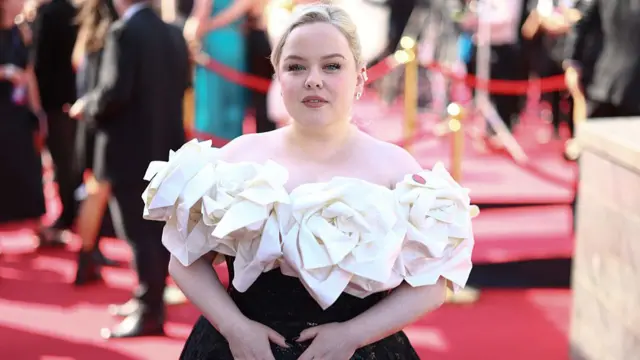 Nicola Coughlan in a black and white evening gown poses on the red carpet