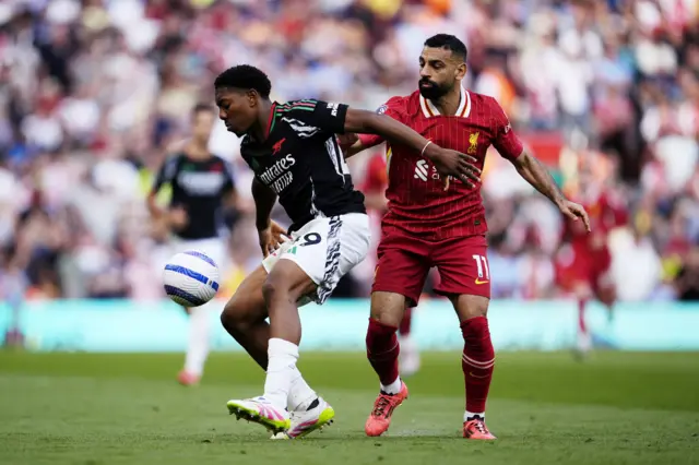 Arsenal's Myles Lewis-Skelly (left) and Liverpool's Mohamed Salah battle for the ball