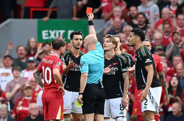 Mikel Merino of Arsenal receives a red card from referee Anthony Taylor during the Premier League match between Liverpool FC and Arsenal FC at Anfield on May 11, 2025 in Liverpool, England.