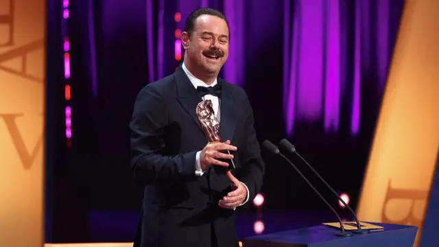 Danny Dyer on stage holds BAFTA award