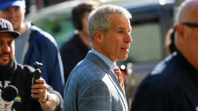 Brian Steel outside court today. He is wearing a blue and grey checkered  suit over blue shirt.