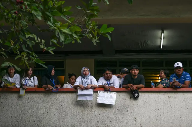 People wait in line to vote at a polling station in Manila, Philippines.