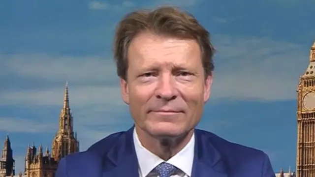 Headshot of Tice sitting wearing a blue suit and a blue tie with white shirt