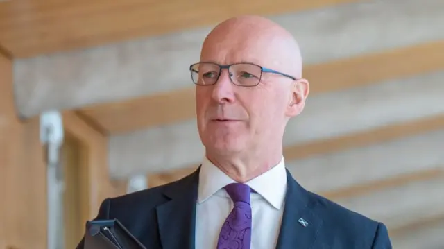 Headshot of Swinney who looks slightly off to the side