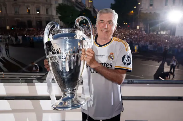 Carlo Ancelotti holding the Champions League trophy