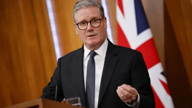 Starmer gestures with his hand during his speech