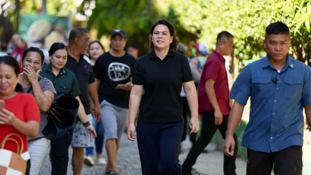 Sara Duterte in a black shirt walking in an open area