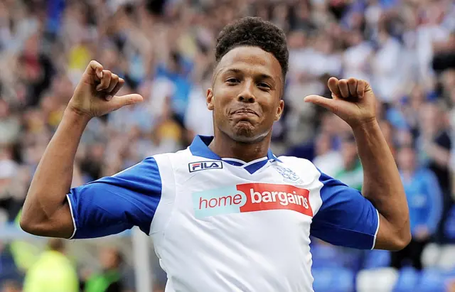 Joe Thompson plays for Tranmere Rovers against Crawley Town in a League One game in August 2013. He is photographed in Tranmere's white shirt with blue sleeves, smiling after scoring a goal.