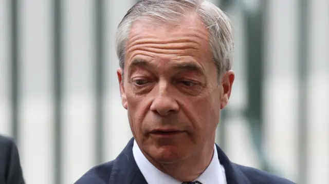 A file photo of Nigel Farage - he is walking in the street wearing a suit